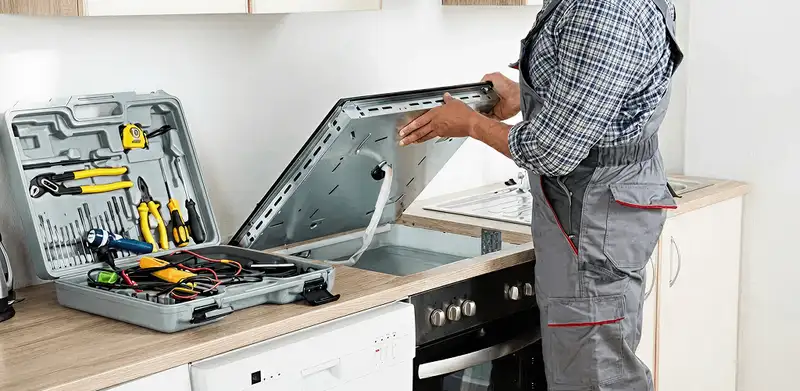 Handyman repairing a cooktop and checking wiring connections in Ogden, UT
