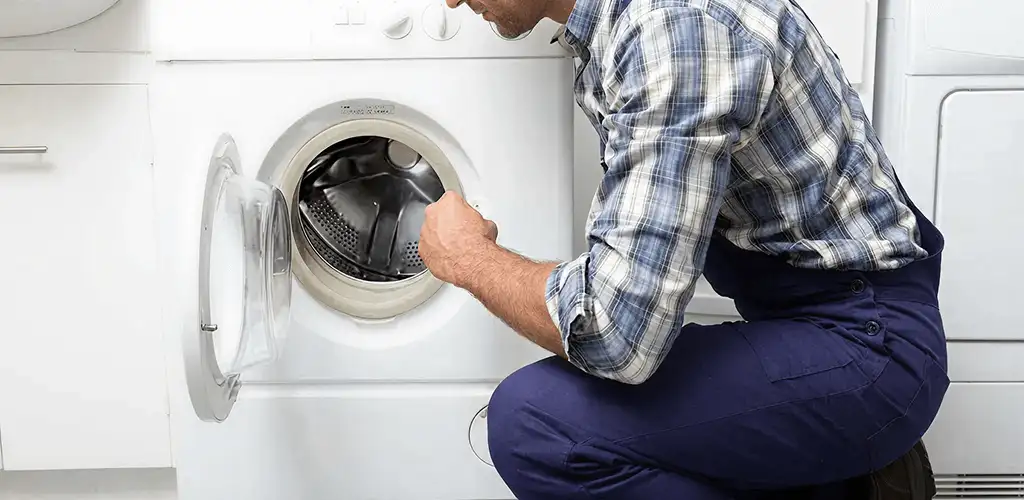 Handyman inspecting a dryer drum and internal parts for repair in Ogden, UT