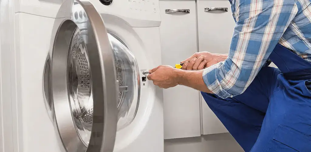 Handyman repairing a clothes dryer and checking electrical connections in Ogden, UT