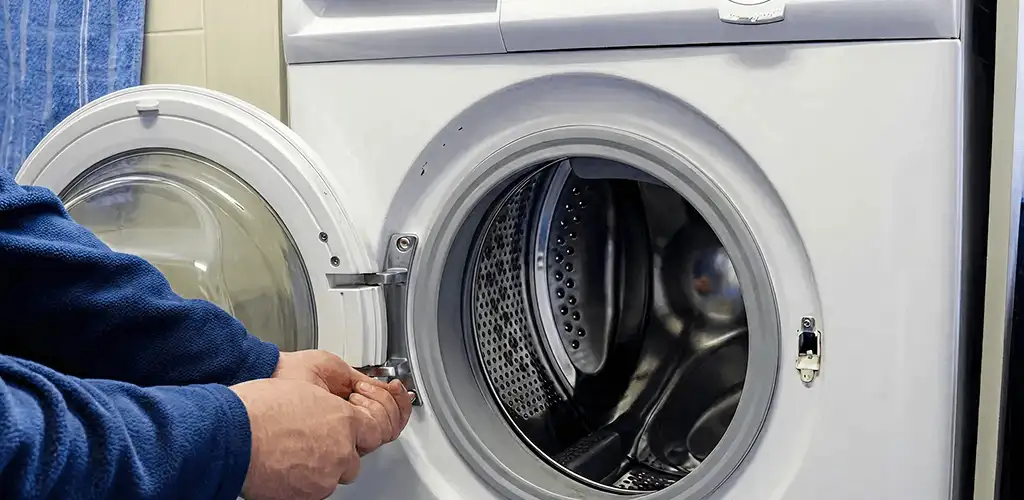 Washing machine repair handyman checking a front-load washer door and latch in Ogden, UT